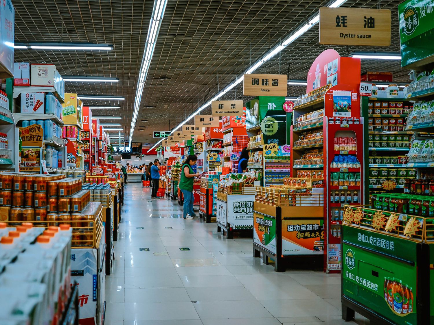 Supermarket aisle analyzed by computer vision: shoppers detected, shelves classified as stocked or low, signage read.